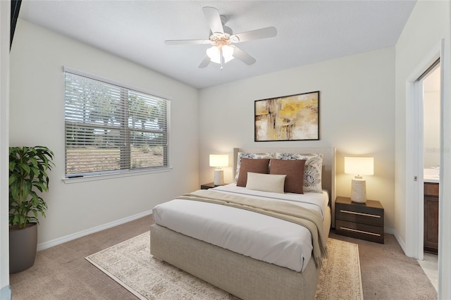 bedroom with light carpet, baseboards, and a ceiling fan