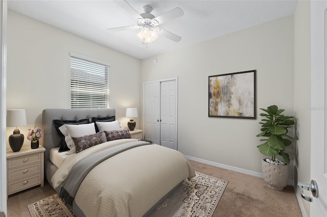 bedroom with a closet, baseboards, a ceiling fan, and light colored carpet