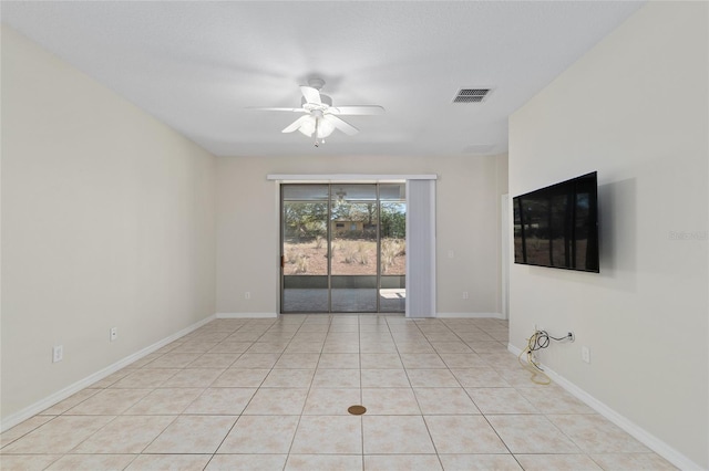 spare room featuring baseboards, visible vents, light tile patterned floors, and a ceiling fan