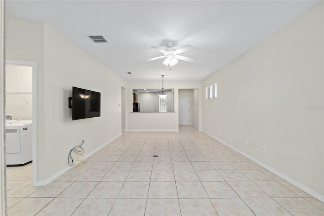unfurnished living room with visible vents, baseboards, washer / clothes dryer, ceiling fan, and light tile patterned floors
