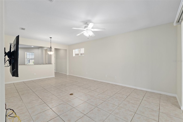 spare room with baseboards, visible vents, and a ceiling fan