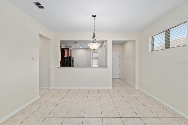 interior space featuring light tile patterned flooring, baseboards, and visible vents