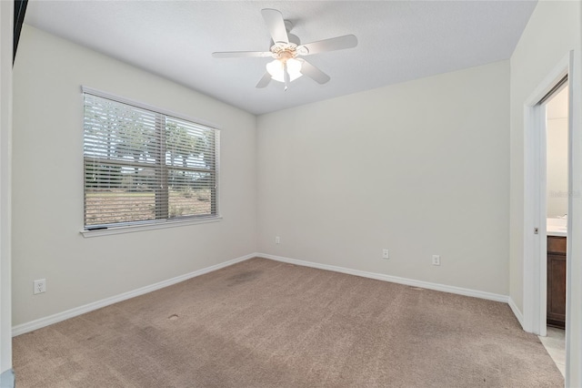 empty room featuring light carpet, baseboards, and ceiling fan