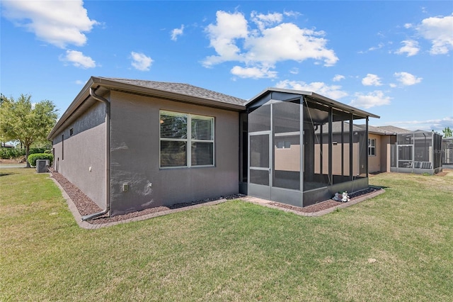 rear view of property featuring cooling unit, stucco siding, a sunroom, and a yard