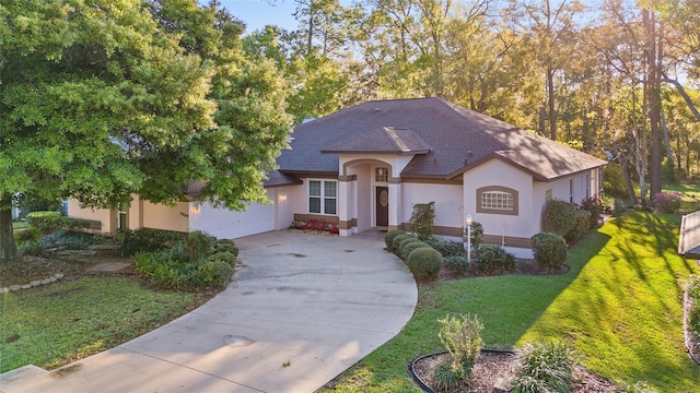 view of front of property with concrete driveway, stucco siding, roof with shingles, a front yard, and a garage