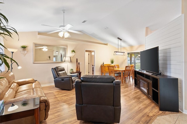 living room featuring vaulted ceiling, visible vents, light wood-type flooring, and ceiling fan