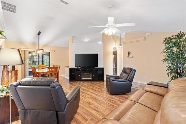 living room with visible vents, baseboards, ceiling fan, light wood-type flooring, and vaulted ceiling