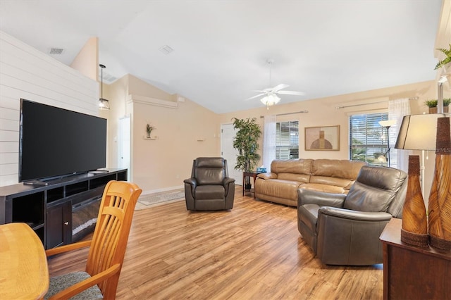 living area featuring visible vents, light wood-style floors, ceiling fan, and vaulted ceiling
