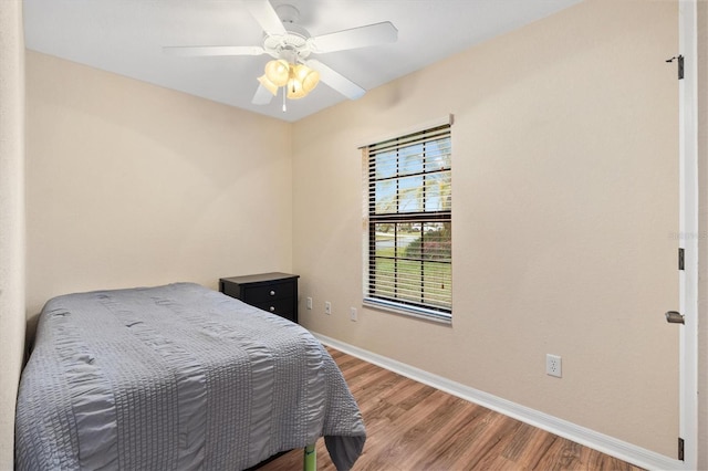 bedroom with ceiling fan, baseboards, and wood finished floors