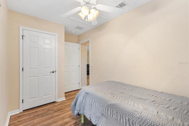 bedroom with visible vents, baseboards, wood finished floors, and a ceiling fan