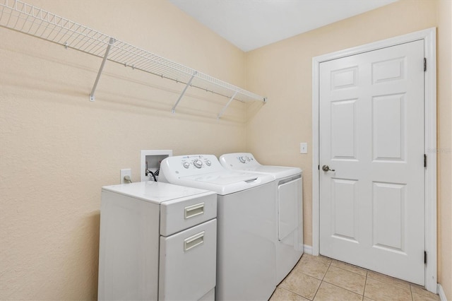 laundry room with laundry area, light tile patterned floors, and washing machine and dryer
