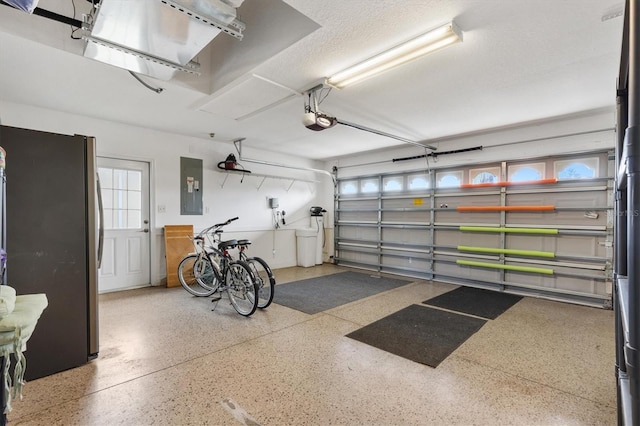 garage with electric panel, a garage door opener, and freestanding refrigerator