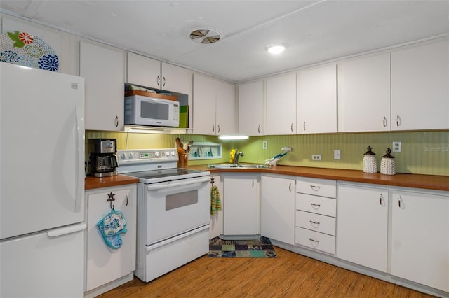 5368 S Parkland Ter, Homosassa, FL 34448 - kitchen featuring white cabinets, white appliances, light wood-style floors, and a sink