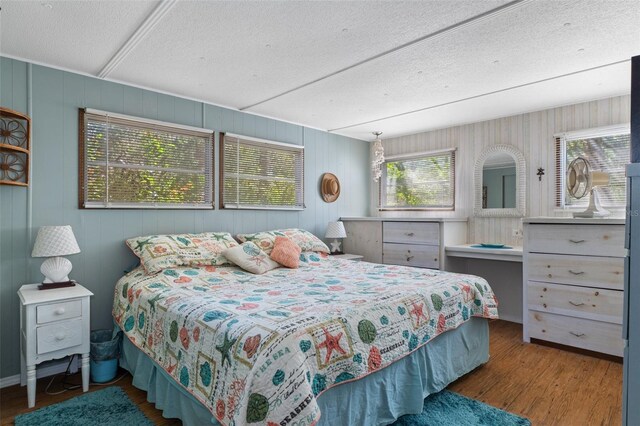 5368 S Parkland Ter, Homosassa, FL 34448 - bedroom with wood walls, wood finished floors, and a textured ceiling