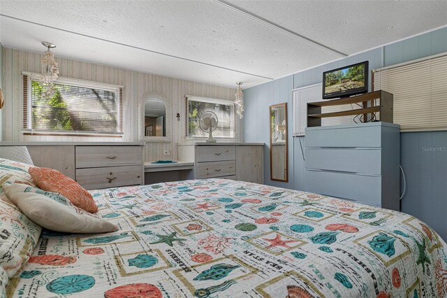 5368 S Parkland Ter, Homosassa, FL 34448 - bedroom featuring wood walls, multiple windows, and a textured ceiling