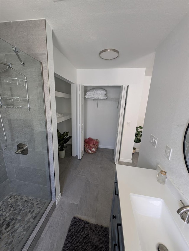 3713 N Suwanee Pt, Crystal River, FL 34428 - full bath with a walk in closet, vanity, a stall shower, and a textured ceiling