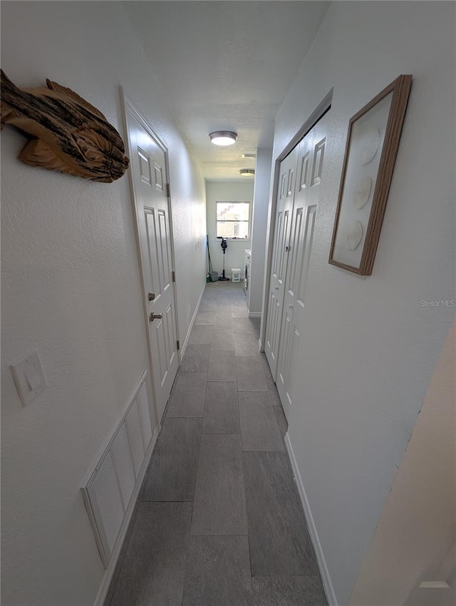 3713 N Suwanee Pt, Crystal River, FL 34428 - corridor featuring visible vents, baseboards, and dark tile patterned flooring