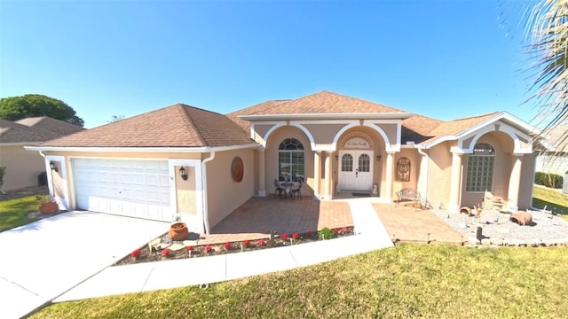 5291 NW 20th Pl, Ocala, FL 34482 - mediterranean / spanish house featuring roof with shingles, an attached garage, stucco siding, concrete driveway, and french doors
