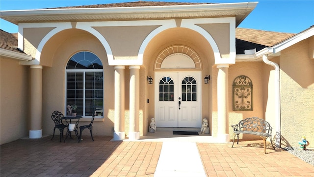 5291 NW 20th Pl, Ocala, FL 34482 - view of exterior entry featuring stucco siding, french doors, and roof with shingles