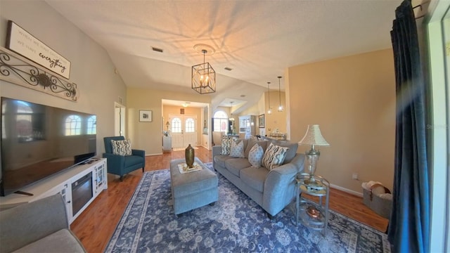 5291 NW 20th Pl, Ocala, FL 34482 - living room featuring vaulted ceiling, a notable chandelier, wood finished floors, and visible vents