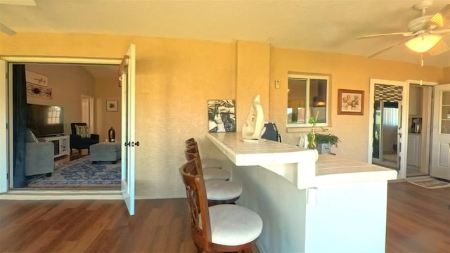 5291 NW 20th Pl, Ocala, FL 34482 - kitchen featuring a ceiling fan, a breakfast bar area, tile countertops, and wood finished floors