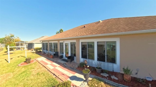 5291 NW 20th Pl, Ocala, FL 34482 - back of house featuring a yard, a patio, roof with shingles, and stucco siding