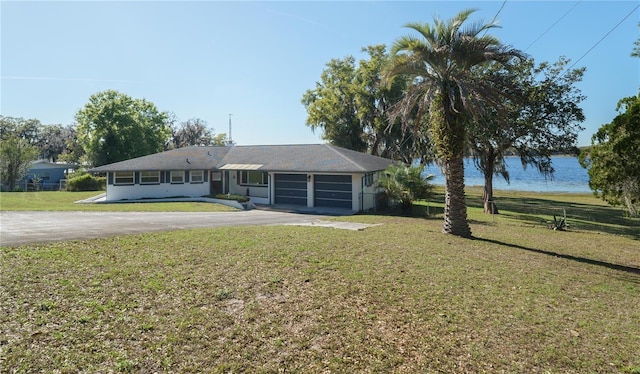 390 SW Shorewood Dr, Dunnellon, FL 34431 - ranch-style house with a front yard, aphalt driveway, a water view, and a garage
