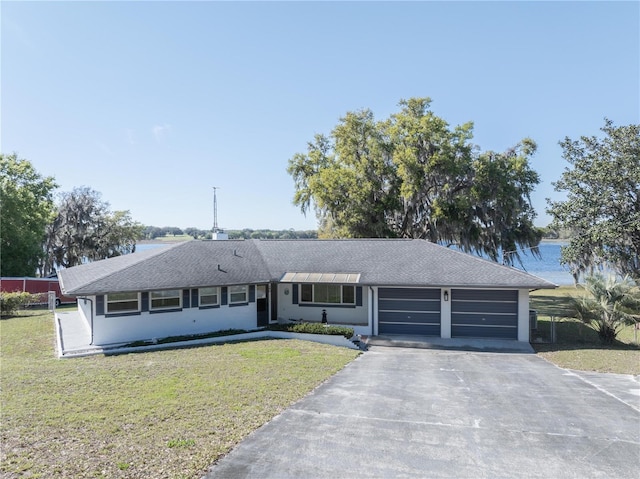 390 SW Shorewood Dr, Dunnellon, FL 34431 - ranch-style house featuring a front yard, driveway, a garage, and roof with shingles