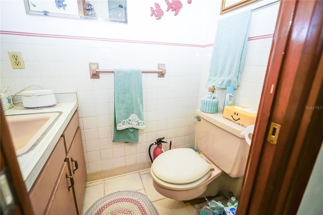 390 SW Shorewood Dr, Dunnellon, FL 34431 - bathroom with toilet, tile walls, vanity, tile patterned flooring, and wainscoting
