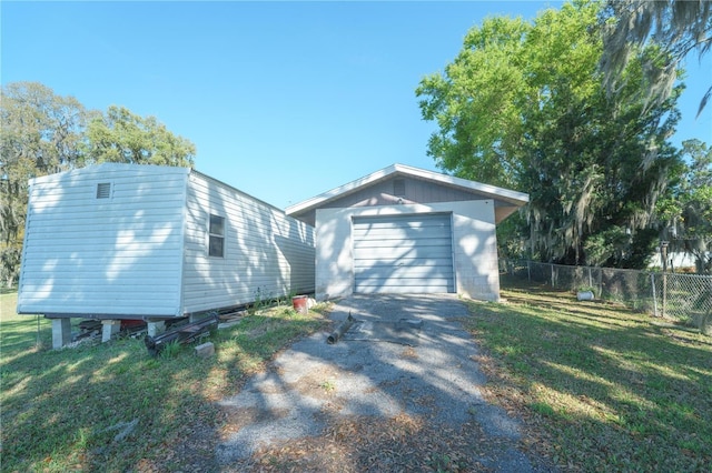 390 SW Shorewood Dr, Dunnellon, FL 34431 - view of property exterior with a yard, fence, aphalt driveway, an outbuilding, and a garage