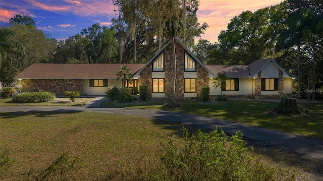 2130 SW 37th Street Rd, Ocala, FL 34471 - tudor-style house with stone siding, a lawn, and driveway