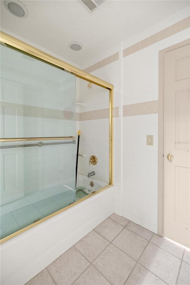 2130 SW 37th Street Rd, Ocala, FL 34471 - bathroom featuring tile patterned flooring, combined bath / shower with glass door, and tile walls