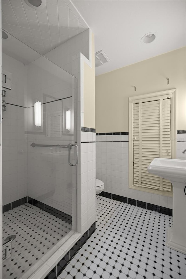 2130 SW 37th Street Rd, Ocala, FL 34471 - bathroom with wainscoting, a shower stall, toilet, and tile walls