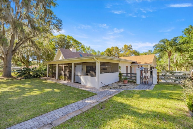 2130 SW 37th Street Rd, Ocala, FL 34471 - rear view of property featuring a yard, fence, a sunroom, and a chimney