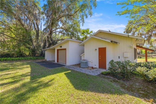 2130 SW 37th Street Rd, Ocala, FL 34471 - exterior space featuring cooling unit, an attached garage, an outdoor structure, and a front lawn