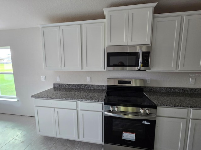 310 W Rexford Dr, Beverly Hills, FL 34465 - kitchen with appliances with stainless steel finishes, white cabinets, and dark stone countertops
