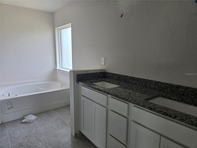 310 W Rexford Dr, Beverly Hills, FL 34465 - full bath with a bath, double vanity, a textured wall, and tile patterned floors