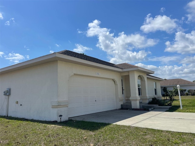 view of side of home featuring concrete driveway, an attached garage, a lawn, and stucco siding