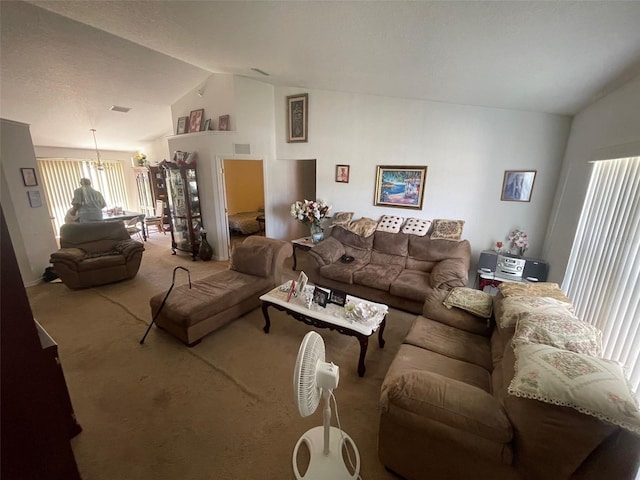 living room with vaulted ceiling, visible vents, and carpet floors