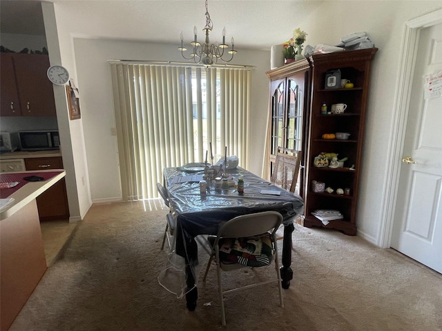 dining room with a chandelier, light carpet, and baseboards