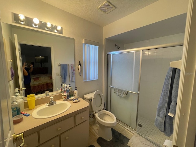ensuite bathroom featuring a stall shower, visible vents, a textured ceiling, and ensuite bath
