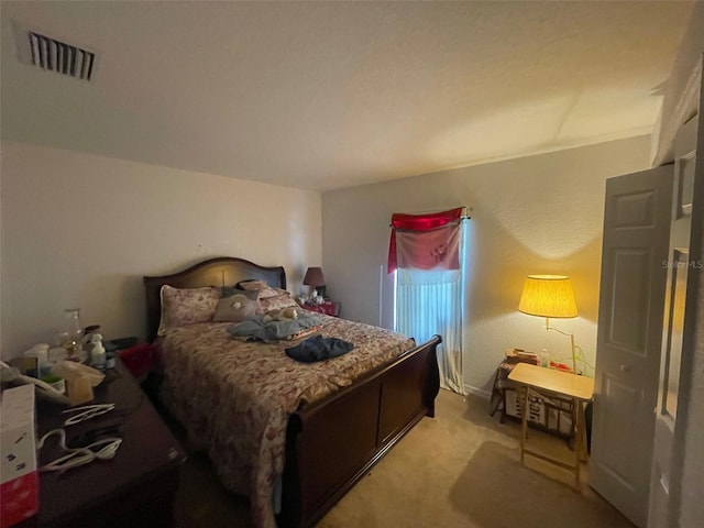 bedroom with visible vents and light carpet