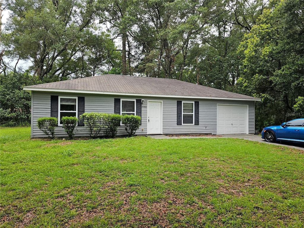 single story home featuring driveway, a garage, and a front lawn