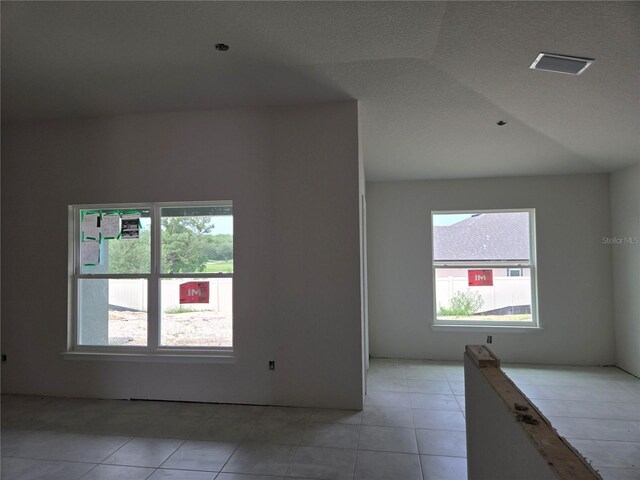 253 W Twisted Oaks Dr, Beverly Hills, FL 34465 - spare room featuring healthy amount of natural light, light tile patterned floors, and lofted ceiling
