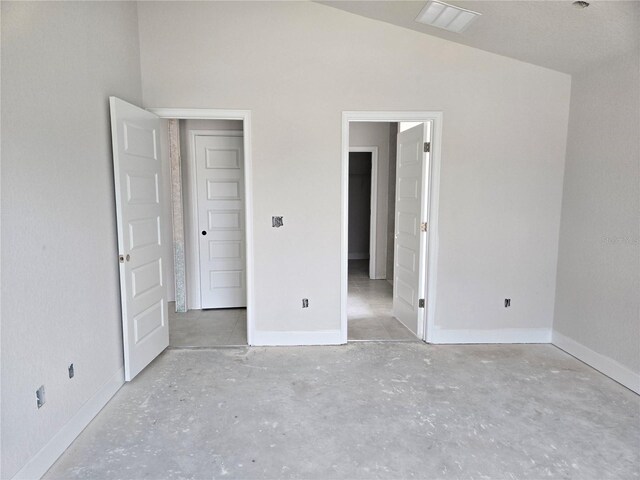 253 W Twisted Oaks Dr, Beverly Hills, FL 34465 - unfurnished bedroom featuring unfinished concrete flooring and vaulted ceiling