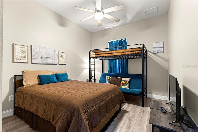 bedroom featuring ceiling fan, baseboards, visible vents, and wood finished floors