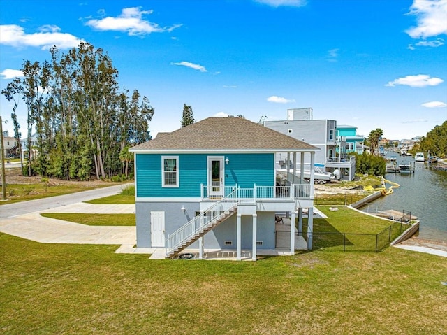 rear view of property with a lawn, stairs, a water view, and roof with shingles