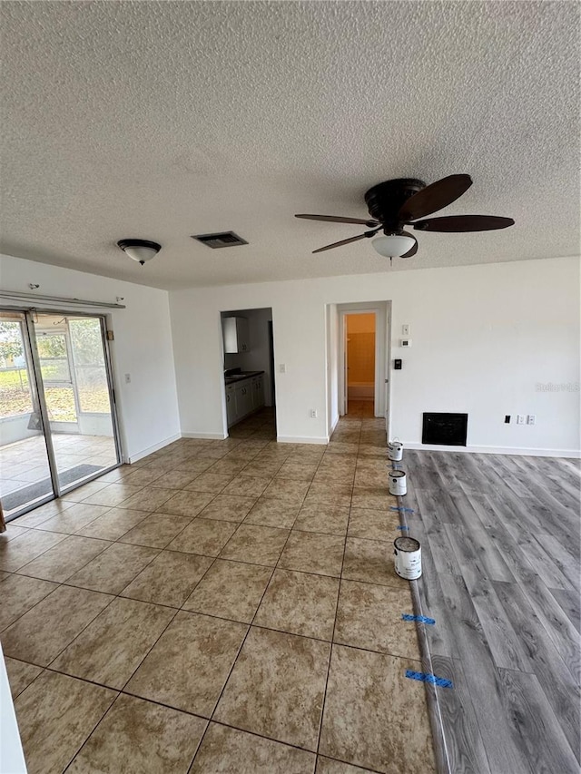 333 Marion Oaks Dr, Ocala, FL 34473 - unfurnished living room with baseboards, ceiling fan, a textured ceiling, and visible vents