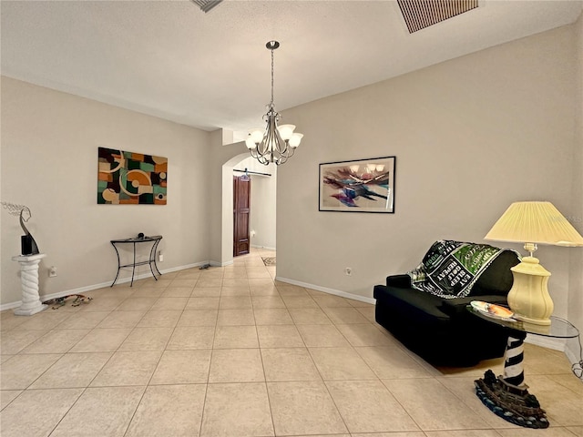 living area featuring a notable chandelier, tile patterned flooring, baseboards, visible vents, and arched walkways
