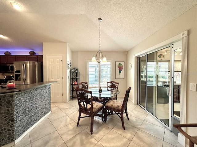 dining area featuring light tile patterned flooring and a textured ceiling